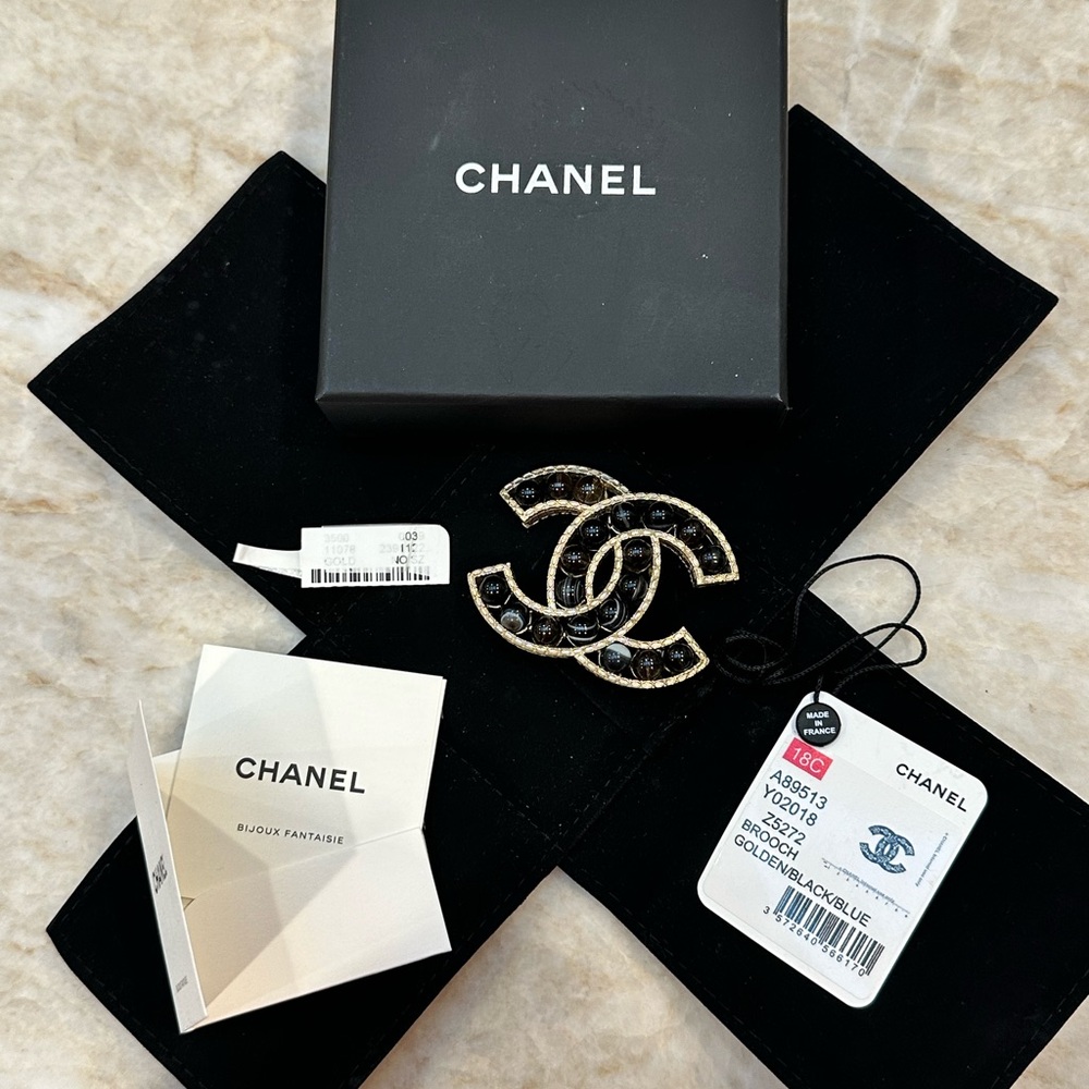 CHANEL CC Logo brooch of Black/blue marbled beads set in gold-tone base.